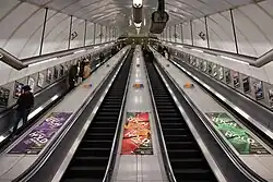 View up the inclined main escalator shaft with four escalators in a line carrying passengers up and down.