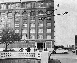 A photograph of the Texas School Book Depository, showing its view from a witness of John F. Kennedy's assassination. The window from the sixth floor is marked A, and another window from the fifth floor is marked B.