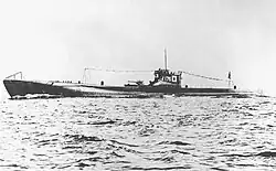 A large submarine underway. Japanese flags and the number "176" are painted on the fin.