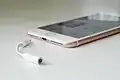 Headphone jack adapter next to an iPhone 7 Plus
