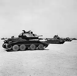 Several tanks parked on sandy-desert surface