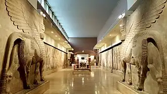Pair of stone lamassu sculptures with human heads and winged bull bodies displayed in the Iraq Museum in 2018