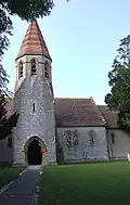 Stone building with square tower which becomes hexagonal near the roof.