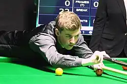 Picture of James Cahill playing snooker.
