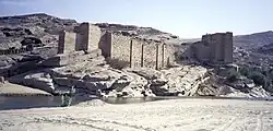 Ruins of a masonry dam located in a desert.