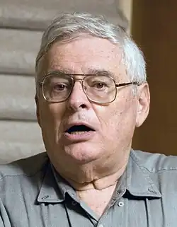 Photo of a man with white hair wearing glasses