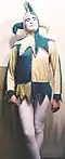 Man dressed as a jester, with a fool's cap, motley and white tights