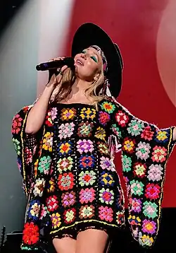 Jewel holding a microphone while singing