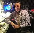 Jim Thornton, seated in a recording booth and wearing a headset