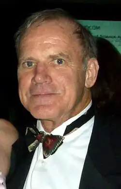 Portrait of a man in a tuxedo with short grayish brown hair, facing the viewer