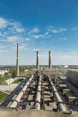 A factory with three large chimneys.