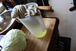 Cloth in a container with whey seen in the bottom