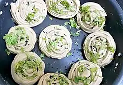 Several spirals of tightly wrapped dough in a pan.