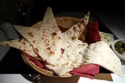 Slices of a flatbread that is very light with some darker, bubbly spots