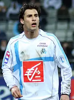 A footballer wearing a white and blue jersey
