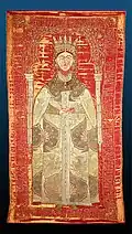 Tapestry of woman with a crown on her head wearing a decorated heavy coat