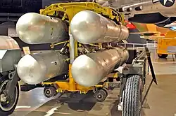 Four silver B28FI nuclear bombs in a rack ready for loading into an aircraft.