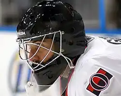 man wearing black goaltender mask and hockey equipment