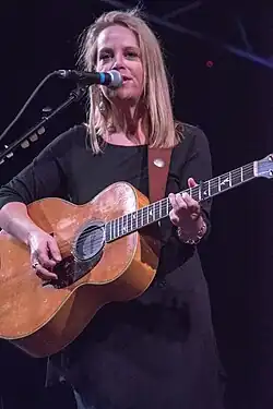 Singer Mary Chapin Carpenter performing while playing a guitar.