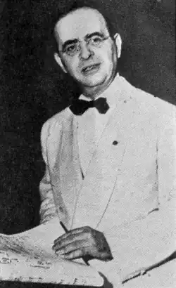 Greyscale photograph of Max Steiner holding music sheets