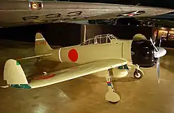 A propellor aircraft on display in a museum: The wing tips are folded up.