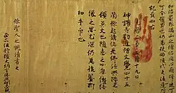 Texts in Chinese letters on brownish aged paper. A red handprint is placed over the text.