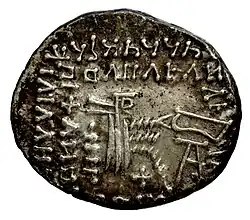 Reverse of a Parthian drahm. The legend at the top reads: [m]trdt MLKA[note 2]. From Mithridates V on, the ruler's full name and title appeared in Parthian script on drahms, while also becoming increasingly stylized.[14]