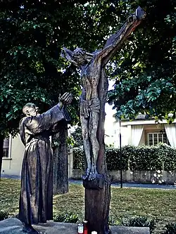 Sculpture of Padre Pio reaching up towards Jesus on the cross, Prato, Tuscany, Italy