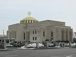 A large grayish stone building, topped with a golden dome