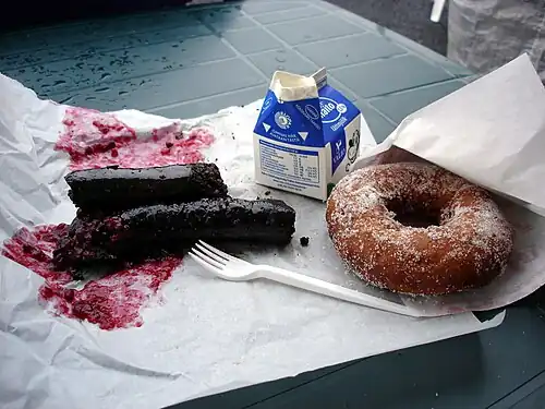 Finnish mustamakkara served with lingonberry jam, milk, and a doughnut