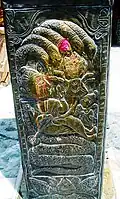 Nāga serving as Vishnu's bed on copper pillar in Kullu, Himachal Pradesh, India