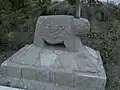 Ram-shaped grave monument embedded in concrete