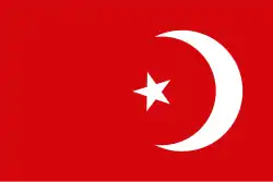A red background on which stands a left-facing, white crescent moon and to the left of that a white star