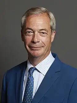 Head shot of Farage slightly smiling in front of a grey background