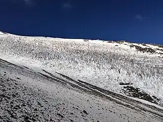 Tooth-like snow forms on a medium-steep slope of a mountain.