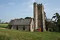Stone building with square tower.