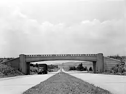 Four-lane highway with overpass, photographed from median