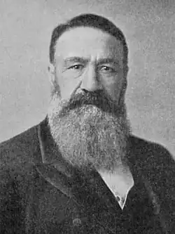 A man with a huge beard and a dark jacket