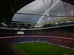 A packed football stadium with overcast sky in the 63rd minute
