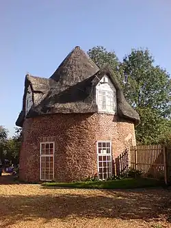 Two storey round thatched cottage with single doorway