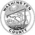 A round seal with a black-and-white depiction of a factory and the county outline