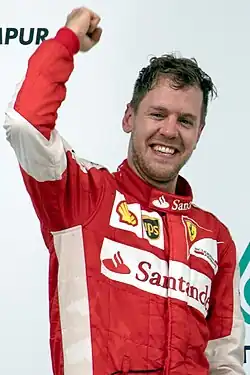 A picture of Sebastian Vettel cheering on the podium after winning the 2015 Malaysian Grand Prix for Ferrari.