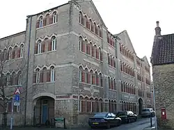 Corner of four-storey building with multiple matching arched windows