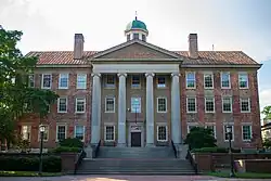 A large building with many windows and four columns on the front.