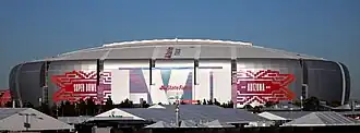photo of State Farm Stadium taken from the parking lot, showing the domed stadium against an overcast sky