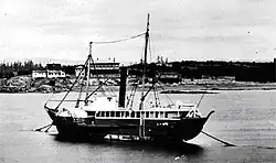 Photograph of the steamship Beaver anchored on a river, showing a side view with masts and paddle structure, circa 1870.