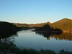 A lake with a forest in the background, which is reflecting upon the water.