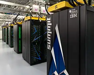 Rows of large, dark computer cabinets in a warehouse-like room