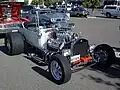 T-bucket with early hemi, but aluminum radiator (rather than brass), rectangular headlights, and five-spokes (rather than motorcycle wheels) mark this as a later incarnation