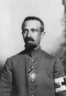 Military Field Rabbi Dr. Aaron Tänzer during World War I, with the ribbon of the Iron Cross.[93] The brassard of the red cross shows him as noncombatant. He wears the Star of David as insignium